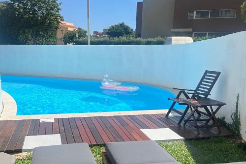 a swimming pool with a chair next to a fence at Signature Guesthouse in Porto