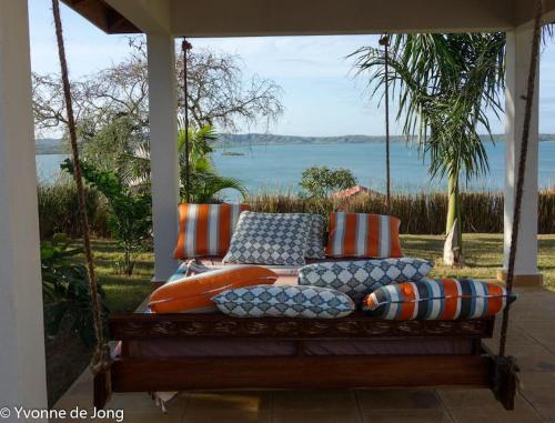 a porch swing with pillows and a view of the water at Coastal Villa Kilifi Creek Mandharini in Kilifi