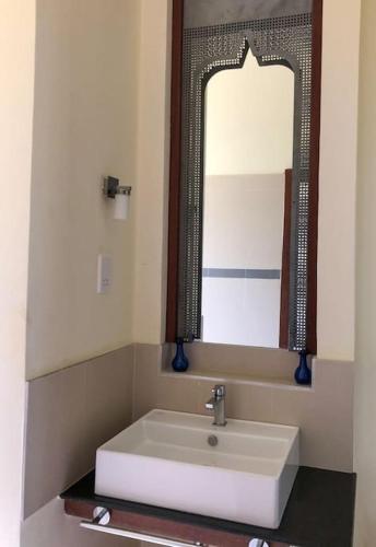 a bathroom with a white sink and a mirror at Coastal Villa Kilifi Creek Mandharini in Kilifi