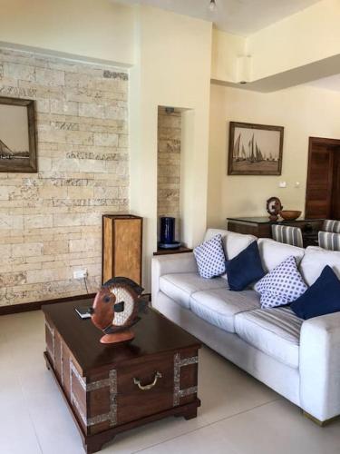 a living room with a couch and a table at Coastal Villa Kilifi Creek Mandharini in Kilifi