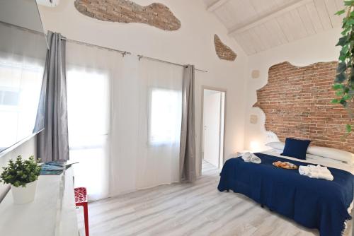 a bedroom with a bed and a brick wall at IzzHome The Breeze in Cagliari