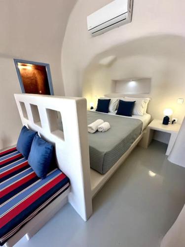 a white bedroom with a bed and a chair at Okeanos Suite 1, Panoramic sea &garden view in Foinikiá