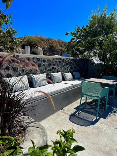 a couch with pillows and a table and a chair at Okeanos Suite 1, Panoramic sea &garden view in Foinikiá
