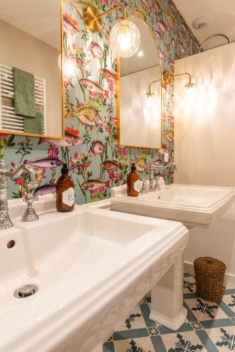 a bathroom with two sinks and a mirror at La Maison 1680 in Couches
