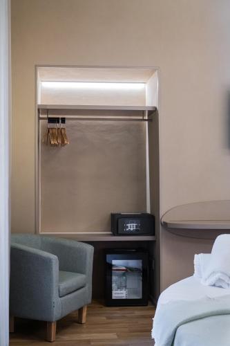 a bedroom with a bed and a chair and a mirror at 163 BOUTIQUE HOTEL in Rome