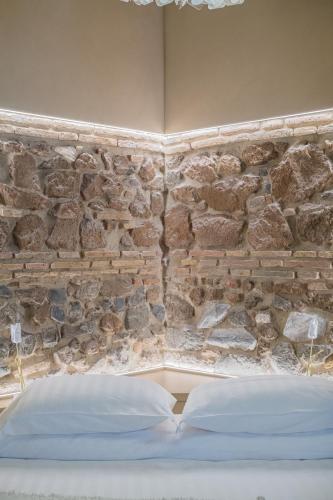 a bed in a room with a stone wall at 163 BOUTIQUE HOTEL in Rome