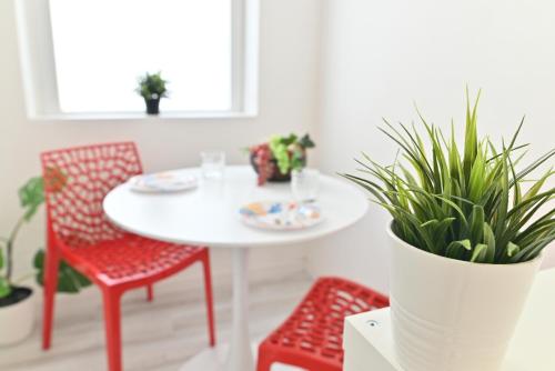 a white table with two chairs and a table with plants at IzzHome The Breeze in Cagliari