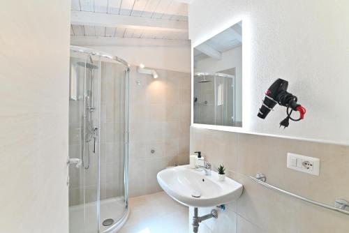 a bathroom with a shower and a sink and a mirror at IzzHome The Breeze in Cagliari