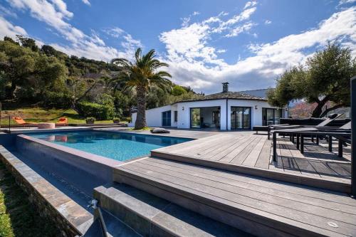 une maison avec une piscine et une terrasse en bois dans l'établissement Les Terrasses de Fromentica, à Saint-Florent