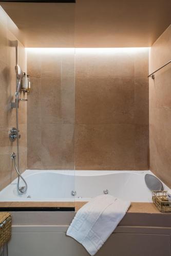 a bathroom with a tub with a glass shower at 163 BOUTIQUE HOTEL in Rome