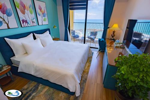 a bedroom with a large white bed and a balcony at Oscar Seaview Apartment in Phu Quoc