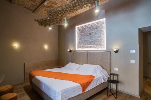 a bedroom with a bed with an orange blanket on it at 163 BOUTIQUE HOTEL in Rome