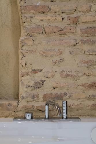 a bathroom sink with a brick wall behind it at 163 BOUTIQUE HOTEL in Rome