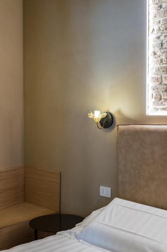 a bedroom with a bed and a lamp on the wall at 163 BOUTIQUE HOTEL in Rome