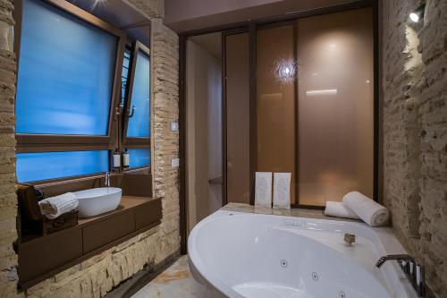 a bathroom with a large tub and a window at 163 BOUTIQUE HOTEL in Rome
