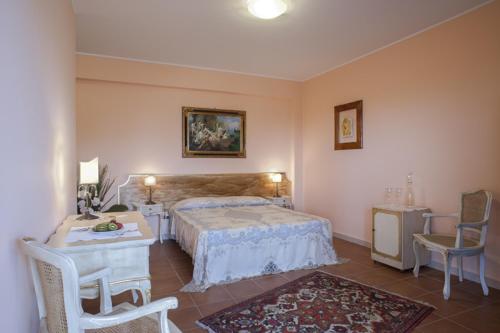 a bedroom with a bed and a table and chairs at La Corte di Opaka in Canosa di Puglia
