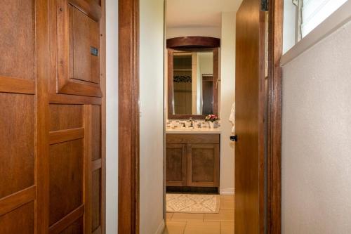 a bathroom with a sink and a wooden door at Hanalei Colony Resort I-2 in Hanalei