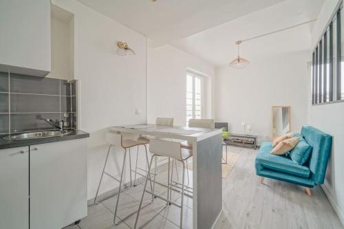 une cuisine avec un comptoir et un fauteuil bleu dans l'établissement Doorman - NEW Audonien Modern 1BR Quick to Paris, à Saint-Ouen
