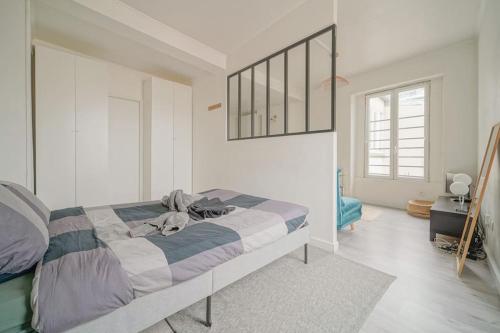 une chambre blanche avec un lit et une fenêtre dans l'établissement Doorman - NEW Audonien Modern 1BR Quick to Paris, à Saint-Ouen