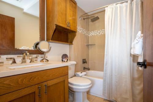 a bathroom with a toilet and a sink and a tub at Hanalei Colony Resort I-2 in Hanalei