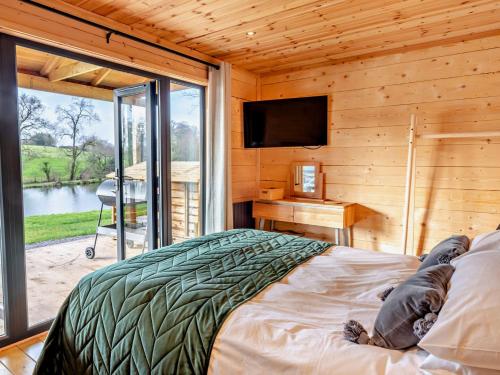 a bedroom with a bed and a television in a cabin at 3 Bed in Cullompton 94139 in Cullompton