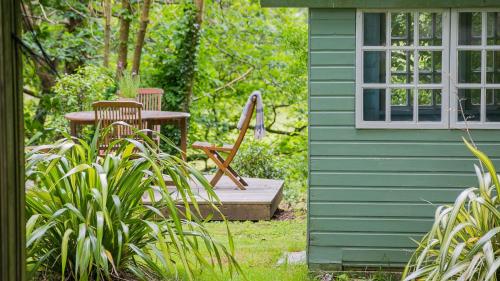 a garden with a table and chairs next to a building at Hafod Cae Maen in Penrhyndeudreath