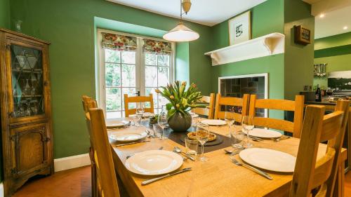 a dining room with a wooden table with chairs at Hafod Cae Maen in Penrhyndeudreath