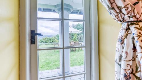a window with a view of a garden at Hafod Cae Maen in Penrhyndeudreath