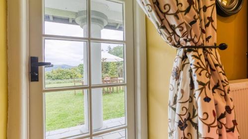 a window with a view of a yard at Hafod Cae Maen in Penrhyndeudreath