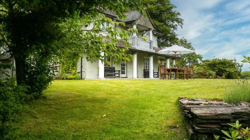 a white house with a lawn in front of it at Hafod Cae Maen in Penrhyndeudreath