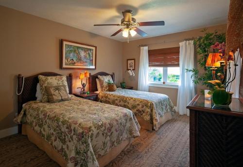 a bedroom with two beds and a ceiling fan at Plantation at Princeville 1322 in Princeville