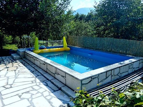a pool with a water slide in a backyard at Vikendica Vučetić Loznica in Budimlija