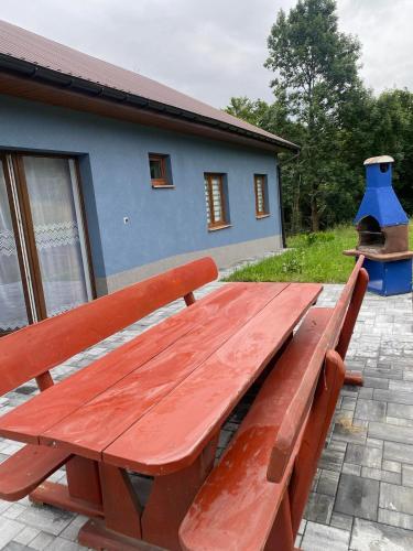 a wooden bench sitting in front of a house at Dom Wakacyjny Cztery Pory Roku in Bystra