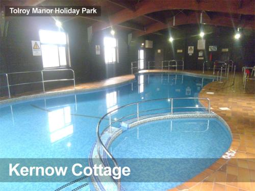 a large swimming pool in a building with the words know cottage at Tolroy Manor - 84 Strawberry Hill in Hayle