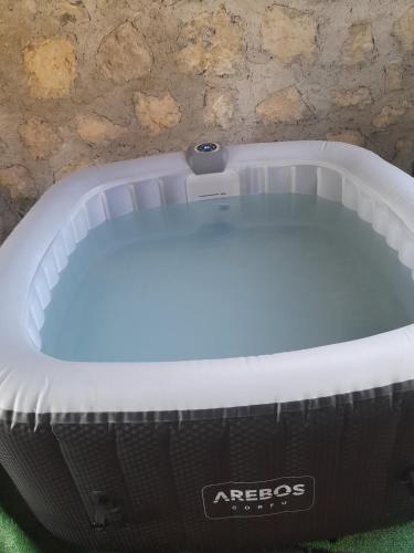 a bath tub sitting on the grass next to a wall at Beb san giorgio in Volpino