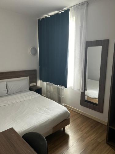 une chambre avec un lit, un miroir et une fenêtre dans l'établissement Le Clémenceau Hôtel et Appart'hôtel & Restaurant 