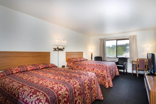 a hotel room with two beds and a television at Cap Sante Inn in Anacortes