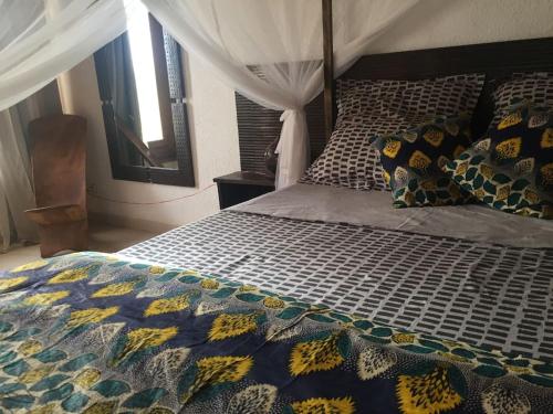 a bedroom with a bed with a comforter and pillows at Warang plage villa in Mbour