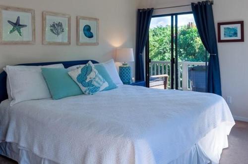 a white bed in a bedroom with a window at Hanalei Bay Villa 26 in Princeville