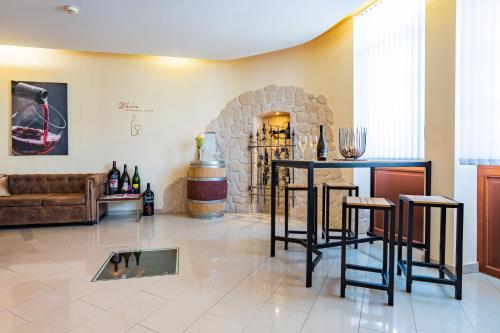 a living room with a table and a stone fireplace at Das Blaufränkisch Weinhotel & Restaurant in Girm