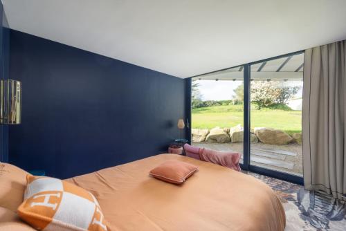 une chambre avec un grand lit et une grande fenêtre dans l'établissement Exclusivité Villa d'Exception en Bord de Mer, à Saint-Cast-le-Guildo