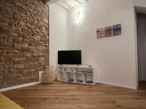 Una sala de estar con un televisor en una pared blanca. en luxury apartment centro storico, en Piombino