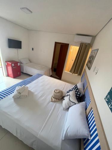 a bedroom with a large white bed with towels on it at Casarao da Terra in Prado
