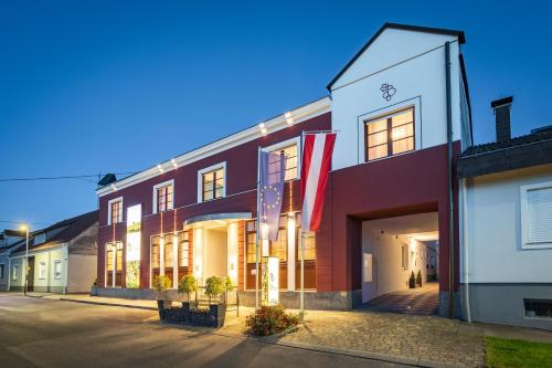 a building with a flag in front of it at Das Blaufränkisch Weinhotel & Restaurant in Girm