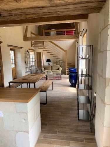 un salon avec des tables en bois et un escalier dans l'établissement Charmante maison en Touraine, entre champs et châteaux, à Razines