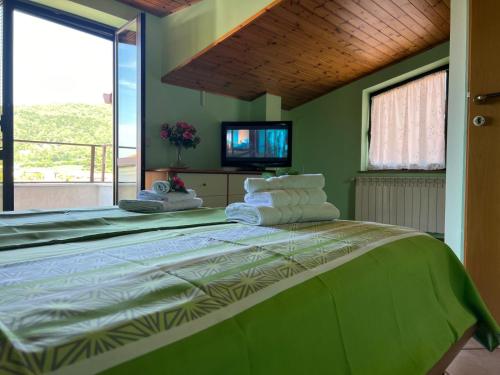 a bedroom with a large bed with a tv on the wall at Apartma Mimi in Dekani
