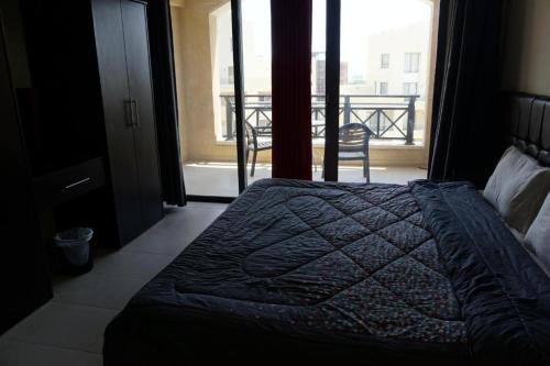 a bedroom with a bed with a view of a balcony at Samarah Resort D44 in Sowayma