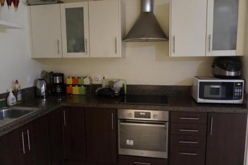 a kitchen with a sink and a stove top oven at Samarah Resort D44 in Sowayma