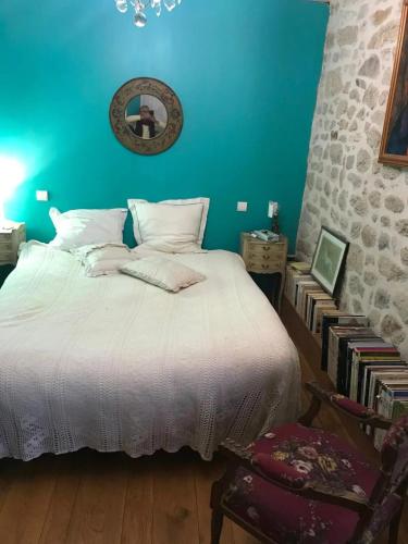 - une chambre avec un lit blanc et un mur bleu dans l'établissement Charmant Moulin De Selves, à Auriac