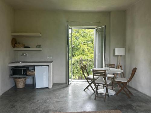 a dining room with a table and chairs and a window at La Torre Granaia in Serravalle Scrivia